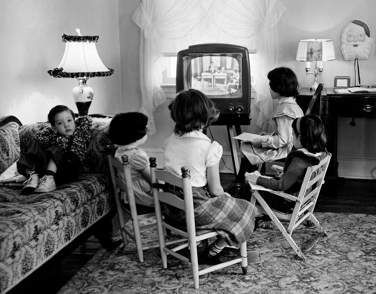 ﻿Children watch TV in 1953. Less-affluent youngsters spend more than three hours daily watching TV and media devices while kids in higher-income homes spend nearly two hours on such activities, a survey says. ﻿