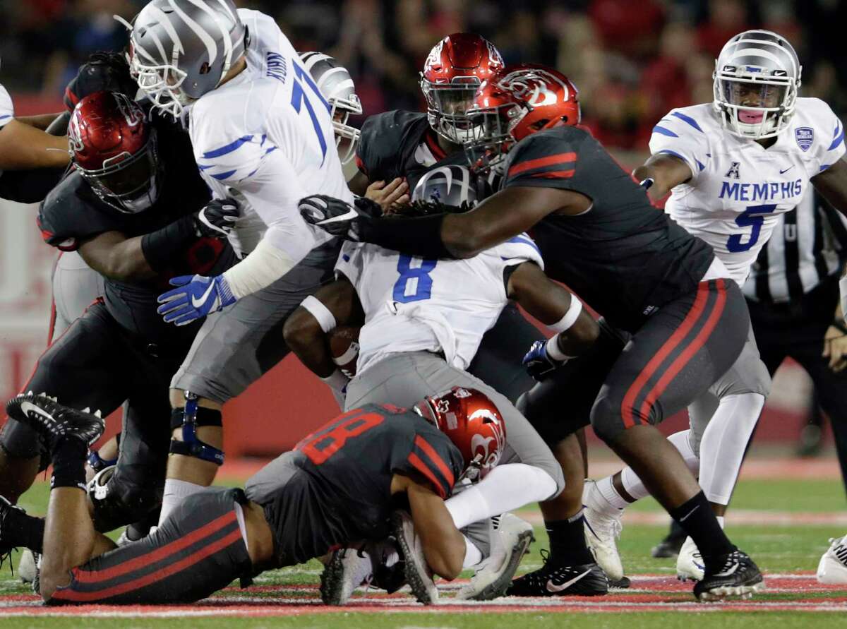Memphis Tigers running back Darrell Henderson #8 is tackled by Houston Cougars cornerback Alexander Myers #18 and defensive end Nick Thurman #91 during the NCAA football game between the Memphis Tigers and the Houston Cougars at TDECU Stadium in Houston, TX on Thursday, October 19, 2017.