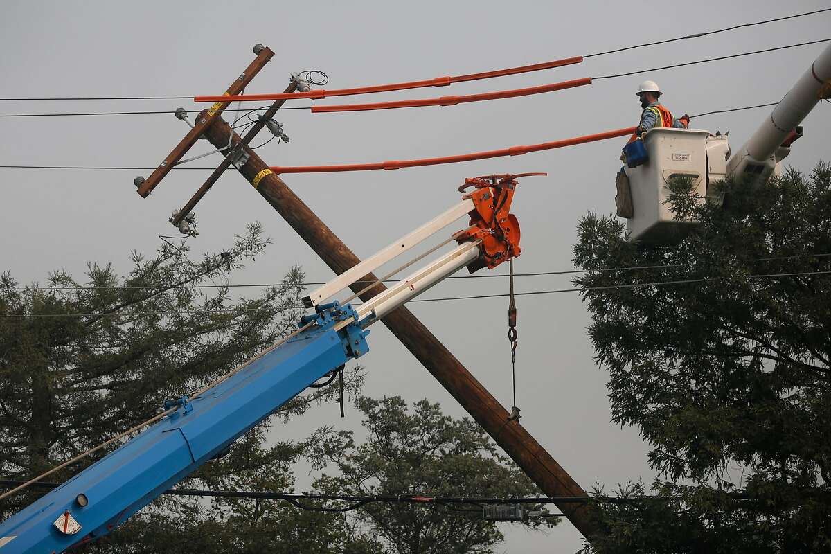 Workers from PG&E work on replacing a downed power line on Cleveland Ave. Oct. 10, 2017 in Santa Rosa, Calif.