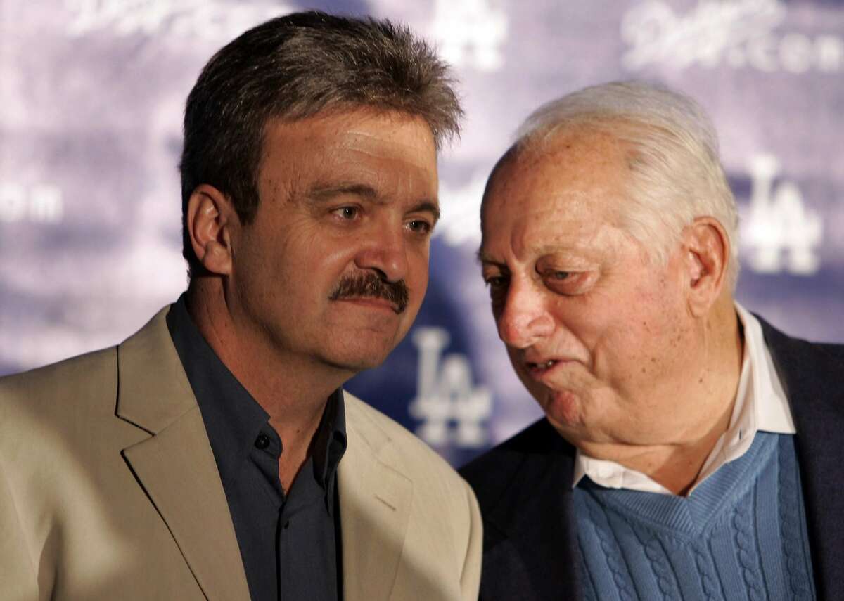 Dodger General Manager Ned Colletti listens to Special Advisor to the Chairman Tommy Lasorda as they introduce new Dodger players centerfielder Juan Pierre and pitcher Randy Wolf at a press conference Wednesday, Nov. 29, 2006 at Dodger Stadium.