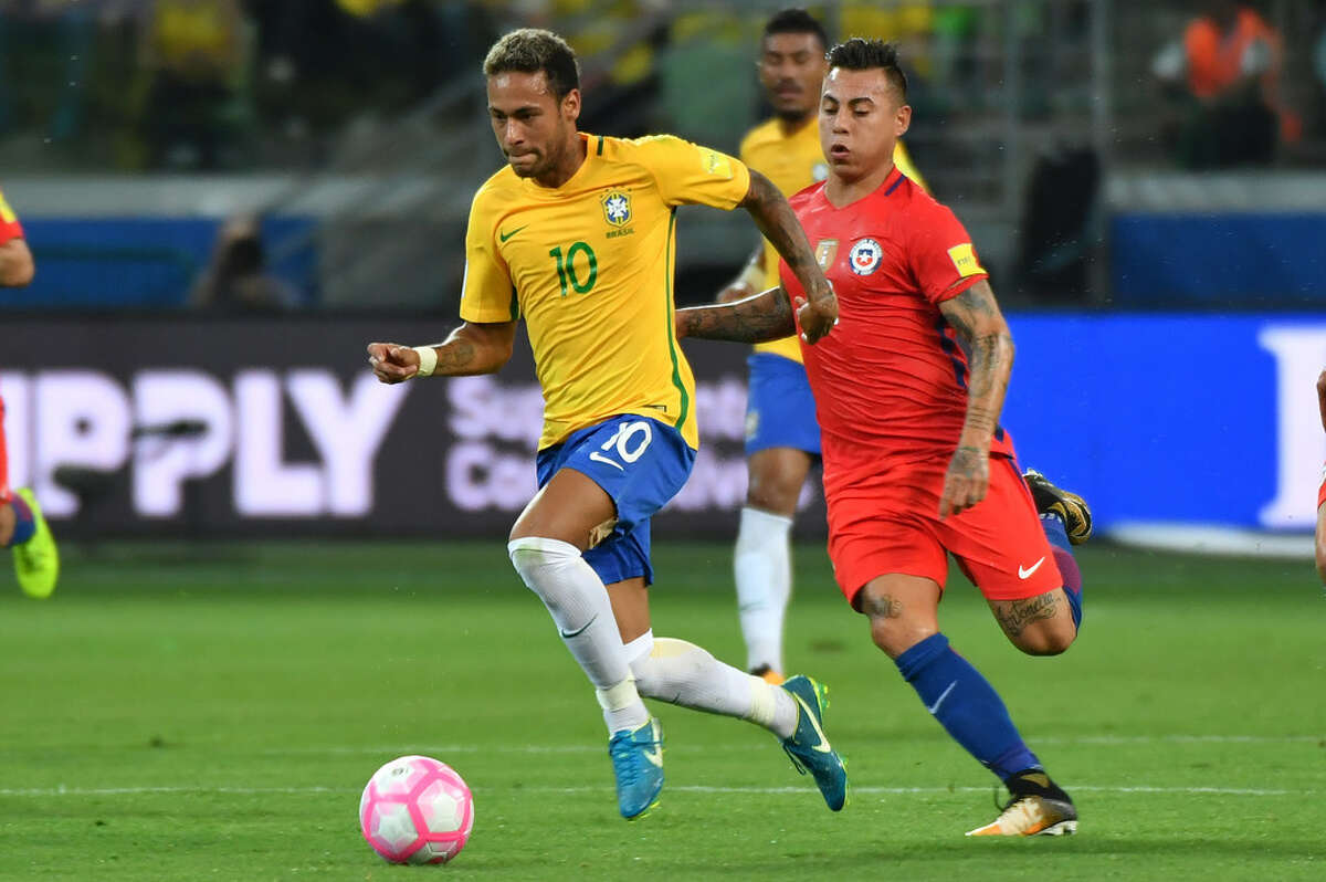 Neymar escapa a la marca de Eduardo Vargas en el triunfo de Brasil que dejó a Chile afuera del Mundial. (AFP)