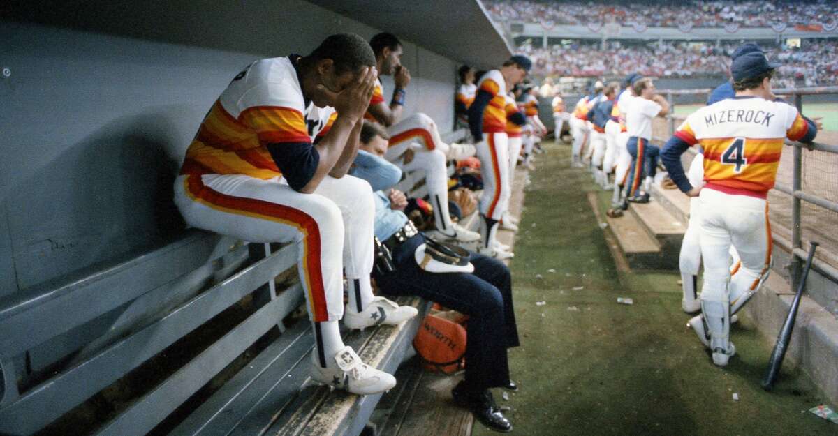 10/15/1986 - The scene in the Houston Astros dugout moments after the final out at the National League Championship Series game 6 against the New York Mets in the Astrodome. Billy Hatcher buries his head in his hands and John Mizerock watches the Mets celebration on the field.