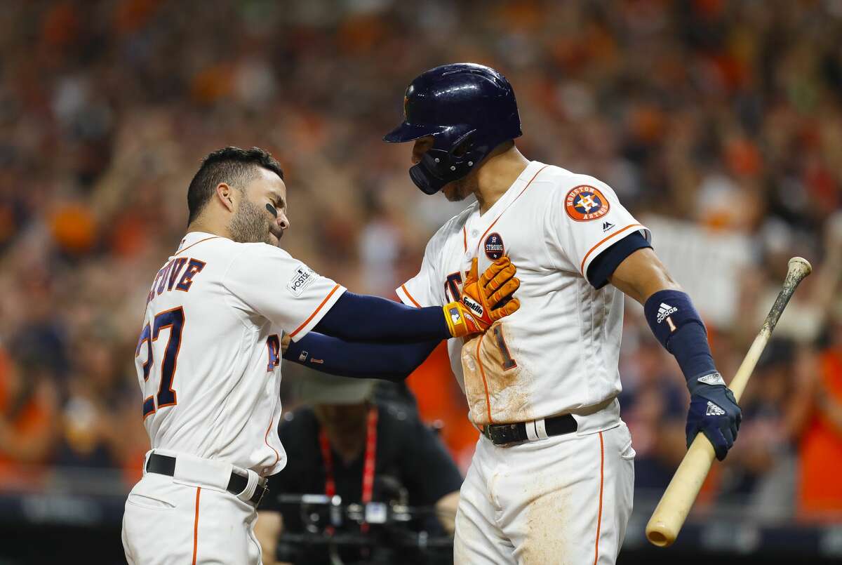 Houston Astros shortstop Carlos Correa (1) welcomes second baseman Jose Altuve (27) home after Altuve hit a home run in the eighth inning of Game 6 of the ALCS at Minute Maid Park on Friday, Oct. 20, 2017, in Houston. ( Brett Coomer / Houston Chronicle )
