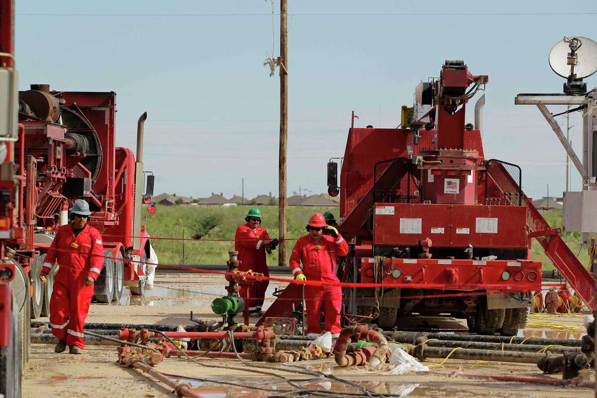 Halliburton employees work at a hydraulic fracturing site in Midland. The oil services giant and its rival Baker Hughes are both valued at about $37 billion on Wall Street. "It's a horse race," energy analyst Byron Pope says.