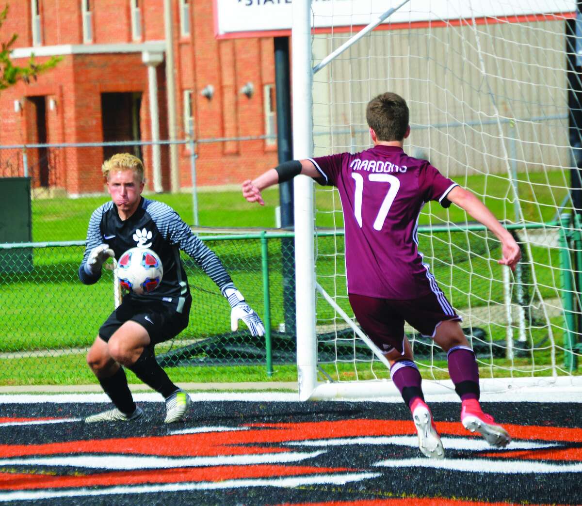 Edwardsville keeper Michael Hoelting, left, chases down a loose ball before Belleville West’s Brayden Easton can get to it in the second half.