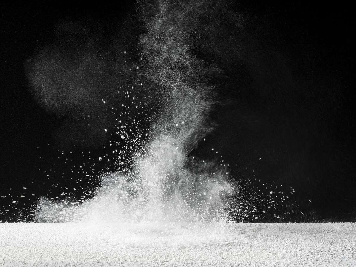 Particles of powder of talc on a black bottom. Photo of study