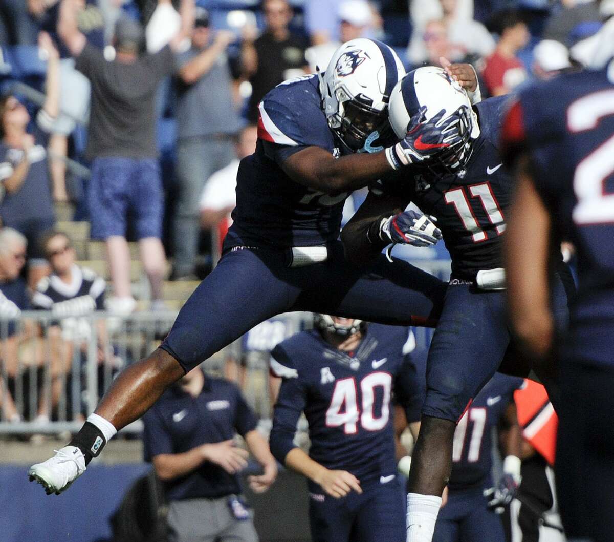 UConn’s Cameron Hairston (87) and Nate Hopkins (11) celebrate after Saturday’s win over Tulsa.