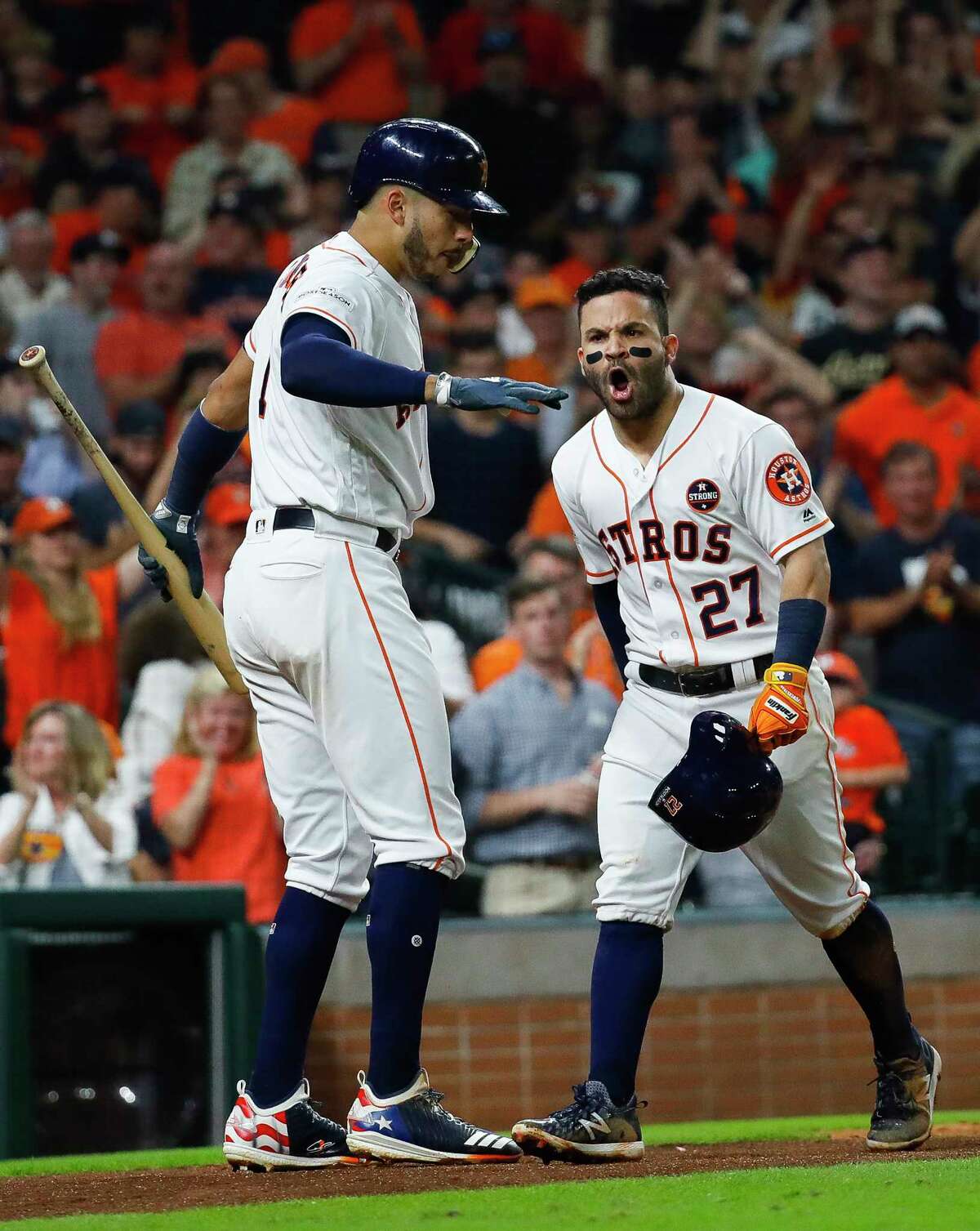 Astros second baseman Jose Altuve, right, and shortstop Carlos Correa celebrate Altuve's solo home run in the fifth inning of Saturday night's ALCS-clinching win over the Yankees at Minute Maid Park.