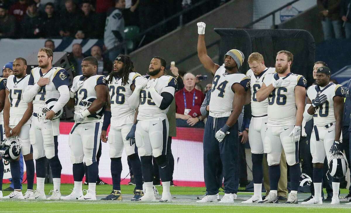 Los Angeles Rams outside linebacker Robert Quinn (94) raises his fist as the national anthem is played before an NFL football game between the Los Angeles Rams and the Arizona Cardinals at Twickenham Stadium in London, Sunday Oct. 22, 2017.