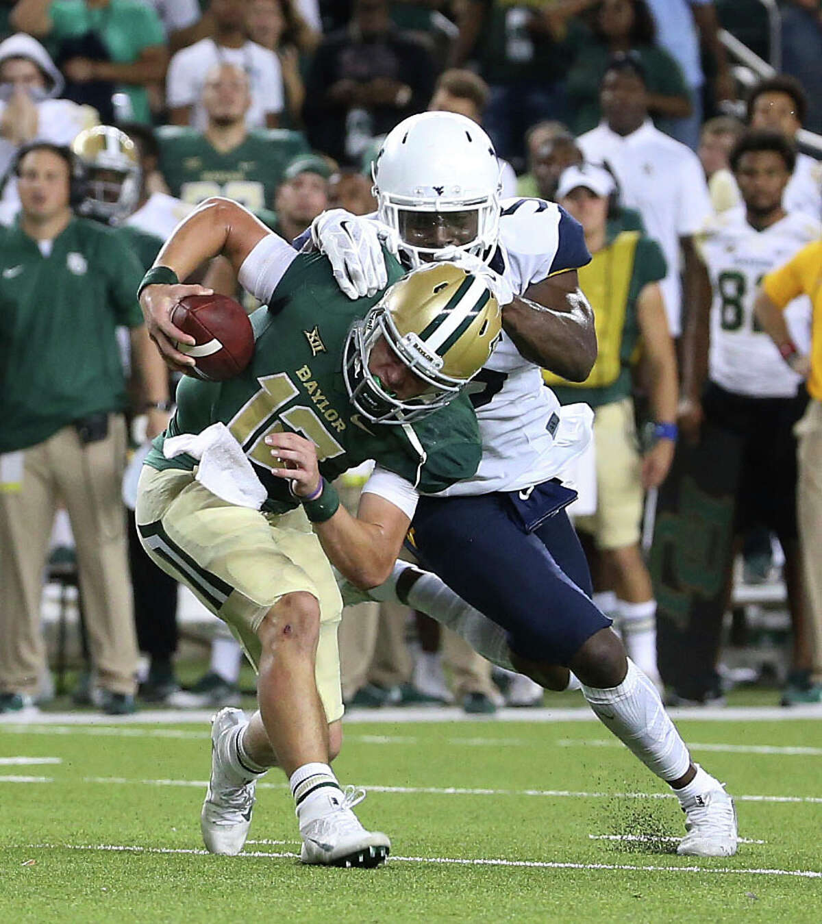 Baylor quarterback Charlie Brewer (12) is is sacked in the final minutes of the NCAA college football game by West Virginia linebacker Xavier Preston (5), Saturday, Oct. 21, 2017, in Waco, Texas. West Virginia won 38-36. (AP Photo/Jerry Larson)