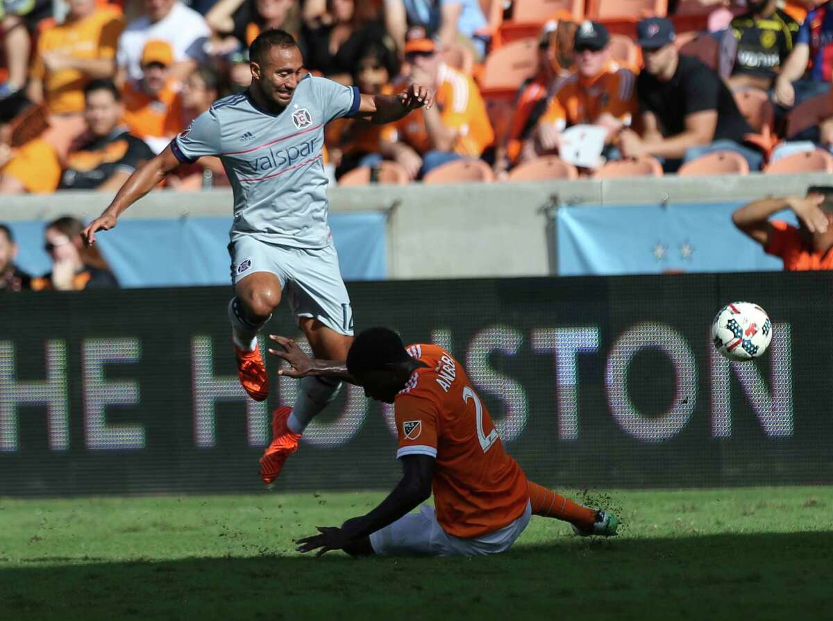 Chicago Fire forward Arturo Alvarez (12) leaps over Houston Dynamo defender Jalil Anibaba (2) while carrying the ball toward the box as Anibaba is trying to get the ball away from him during the first half of the last MLS regular game at BBVA Compass Stadiujm on Sunday, Oct. 22, 2017, in Houston.