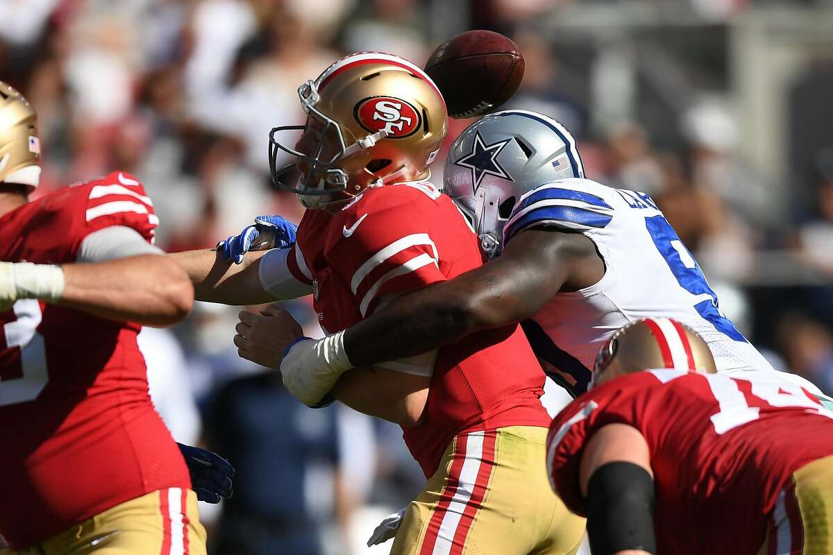 C.J. Beathard #3 of the San Francisco 49ers is stripped of the ball by DeMarcus Lawrence #90 of the Dallas Cowboys during their NFL game at Levi's Stadium on October 22, 2017 in Santa Clara, California.