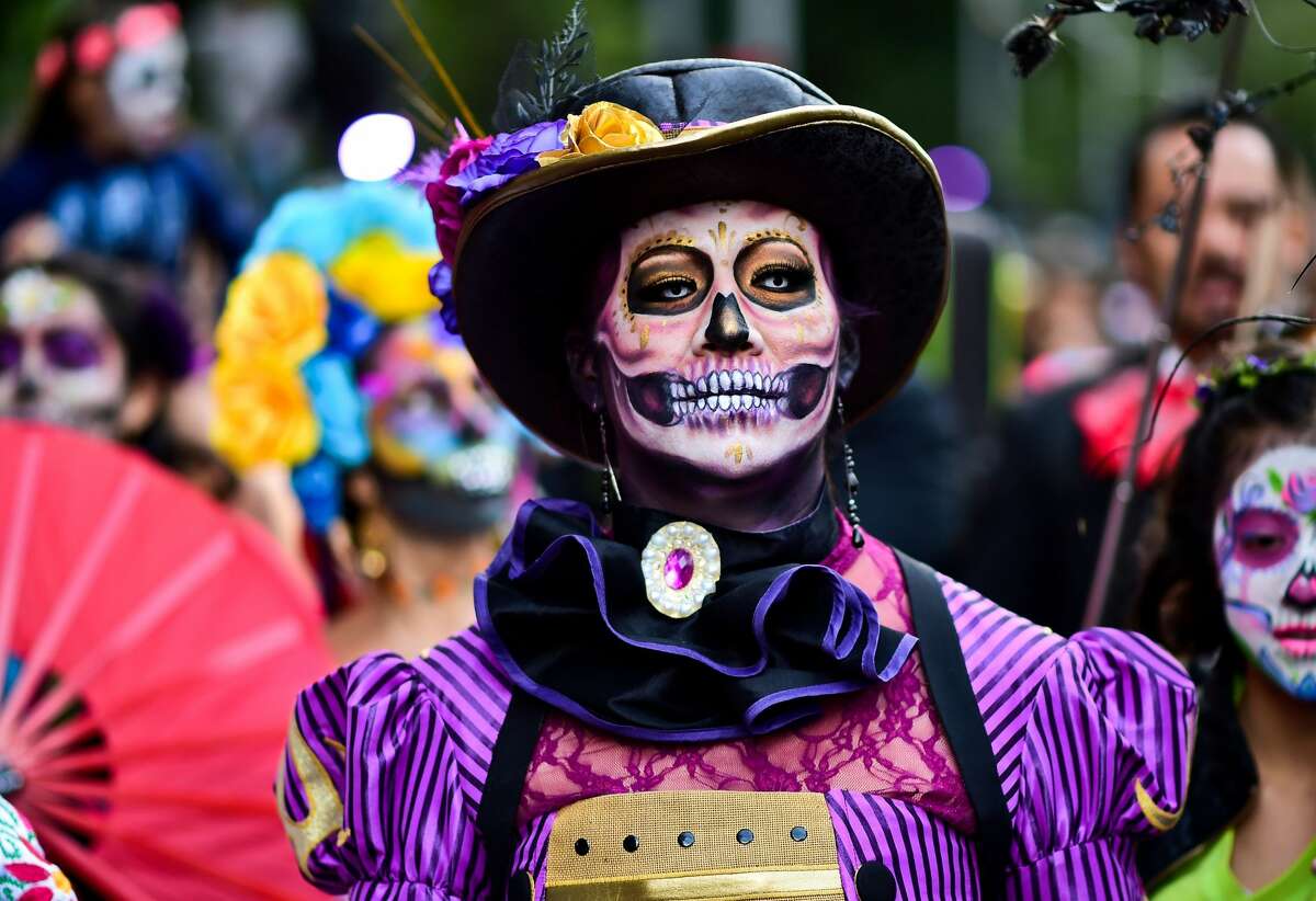 People disguised as "Catrina" (Mexican representation of death) take part in the "Catrinas Parade" along Reforma Avenue, in Mexico City on October 22, 2017. Mexicans get ready to celebrate the Day of the Dead highlighting the character of La Catrina which was created by cartoonist Jose Guadalupe Posada, famous for his drawings of typical local, folkloric scenes, socio-political criticism and for his illustrations of "skeletons" or skulls, including La Catrina.