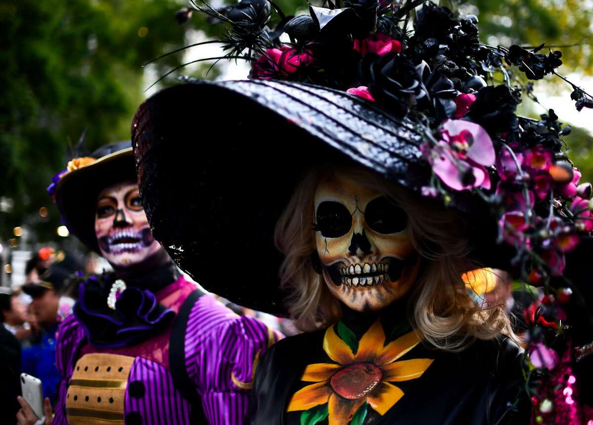People fancy dressed as "Catrina" take part in the "Catrinas Parade" along Reforma Avenue, in Mexico City on October 22, 2017. Mexicans get ready to celebrate the Day of the Dead highlighting the character of La Catrina which was created by cartoonist Jose Guadalupe Posada, famous for his drawings of typical local, folkloric scenes, socio-political criticism and for his illustrations of "skeletons" or skulls, including La Catrina.