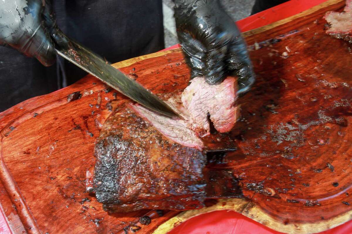 Matthew Rudofker, culinary director for the Momofuku restaurant group, slicing ribs at Southern Smoke 2017.