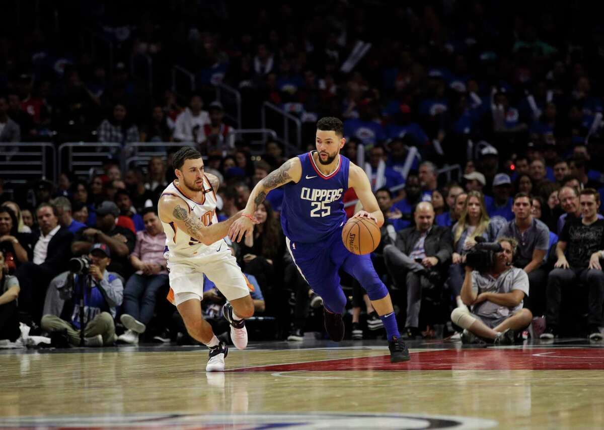 Los Angeles Clippers' Austin Rivers drives past Phoenix Suns' Mike James during the second half of an NBA basketball game Sunday, Oct. 22, 2017, in Los Angeles. (AP Photo/Jae C. Hong)