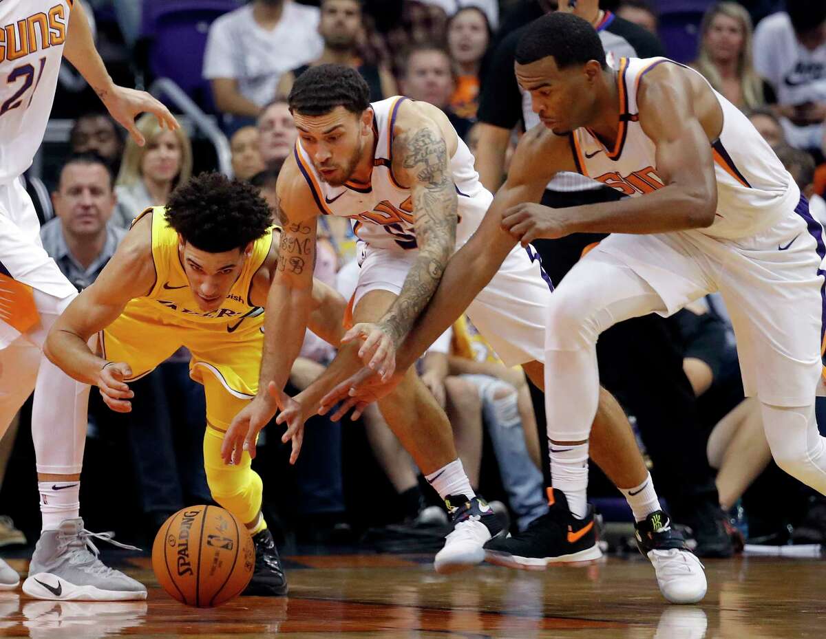 Los Angeles Lakers guard Lonzo Ball, left, loses the ball as Phoenix Suns guard Mike James, center, and forward TJ Warren defend during the second half of an NBA basketball game, Friday, Oct. 20, 2017, in Phoenix. (AP Photo/Matt York)