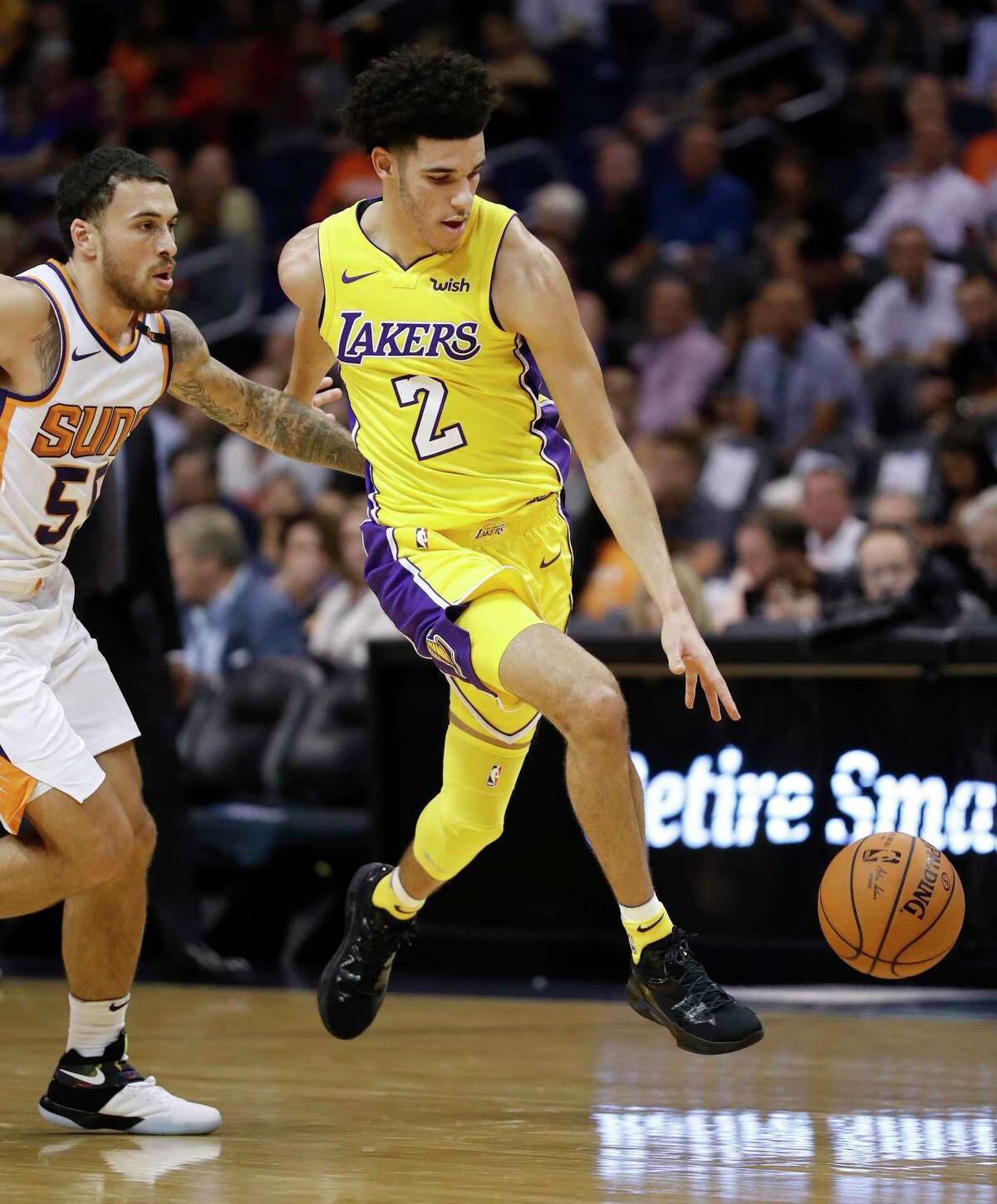 Los Angeles Lakers guard Lonzo Ball (2) pushes the ball past Phoenix Suns guard Mike James (55) during the first half of an NBA basketball game, Friday, Oct. 20, 2017, in Phoenix. (AP Photo/Matt York)