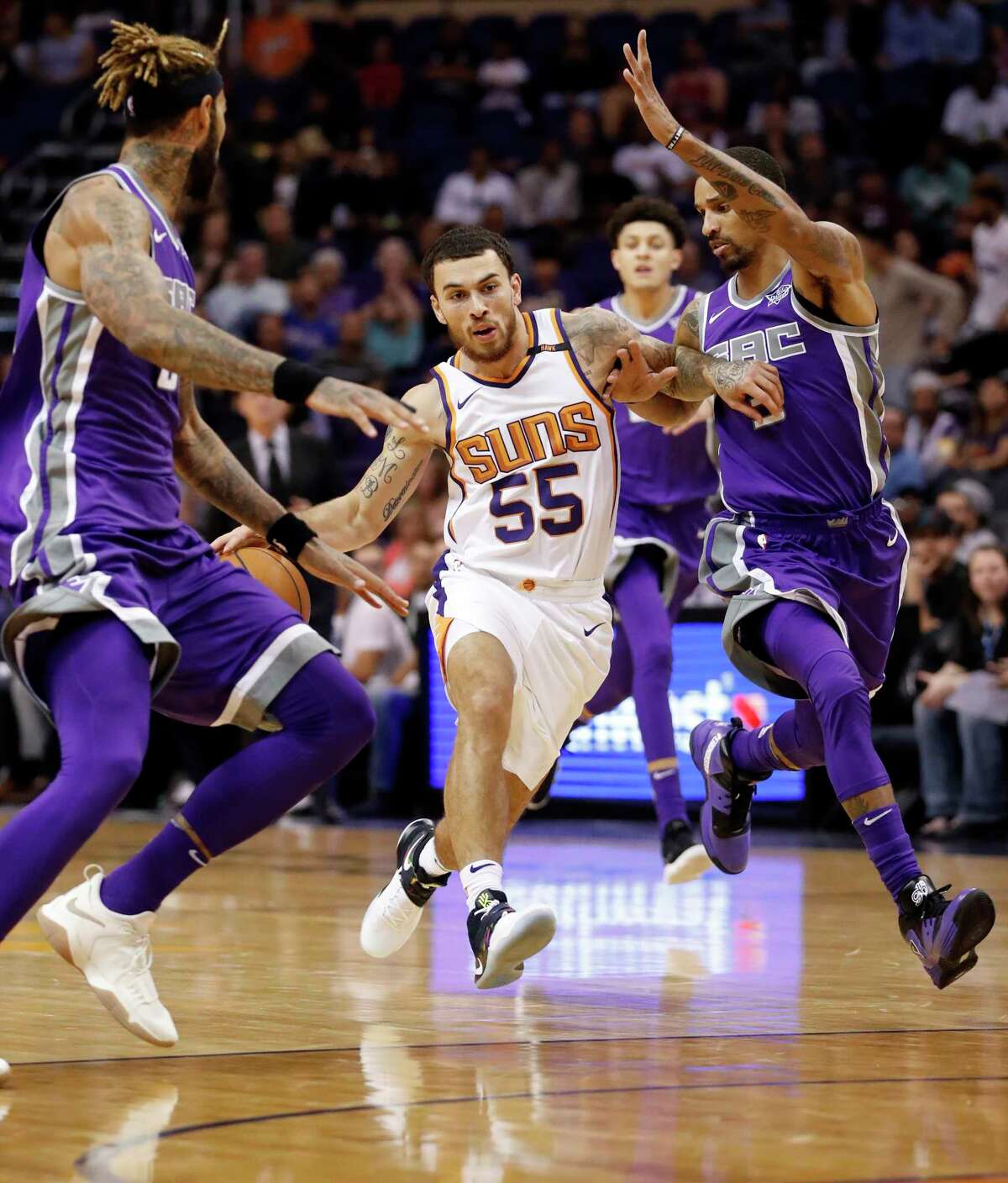 Phoenix Suns guard Mike James (55) drives as Sacramento Kings center Willie Cauley-Stein, left and Sacramento Kings guard George Hill, right, during the second half of an NBA basketball game, Monday, Oct. 23, 2017, in Phoenix. The Suns won 117-115. (AP Photo/Matt York)