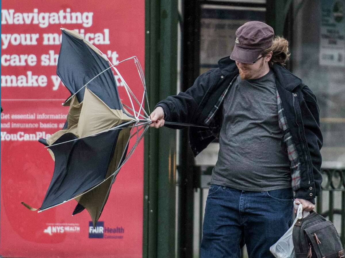 A commuter left the bus and opened his umbrella on State Street and it lost it's shape in the high winds and rain that came to the area Tuesday Oct. 24, 2017 in Albany, N.Y. The same type of weather is expected for Monday, April 16, 2018. (Skip Dickstein/Times Union)