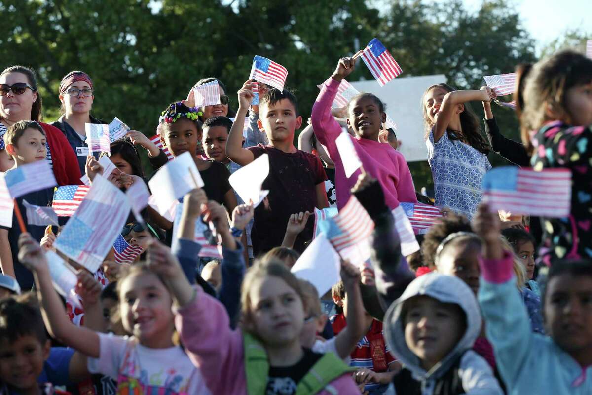 Children wave U.S. flags during the Parade of Nations at Colonies North Elementary School in 2017. The school has a long history of serving refugees from around the world. Research has shown that, nationally, much work needs to be done to improve education for English Language Learners.