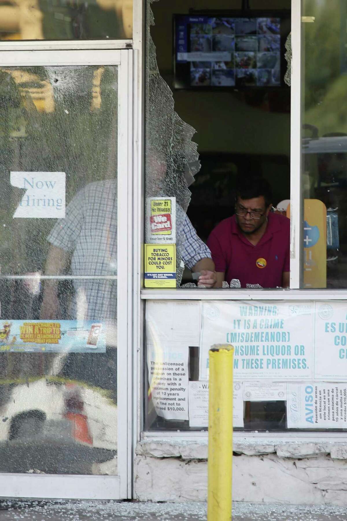 Personnel clean up shattered glass at the Hays Food Mart at the corner of North New Braunfels Avenue and Hays Street, Sunday, Sept. 17, 2017. Earlier in the morning, three people were shot in a drive-by shooting at the store.