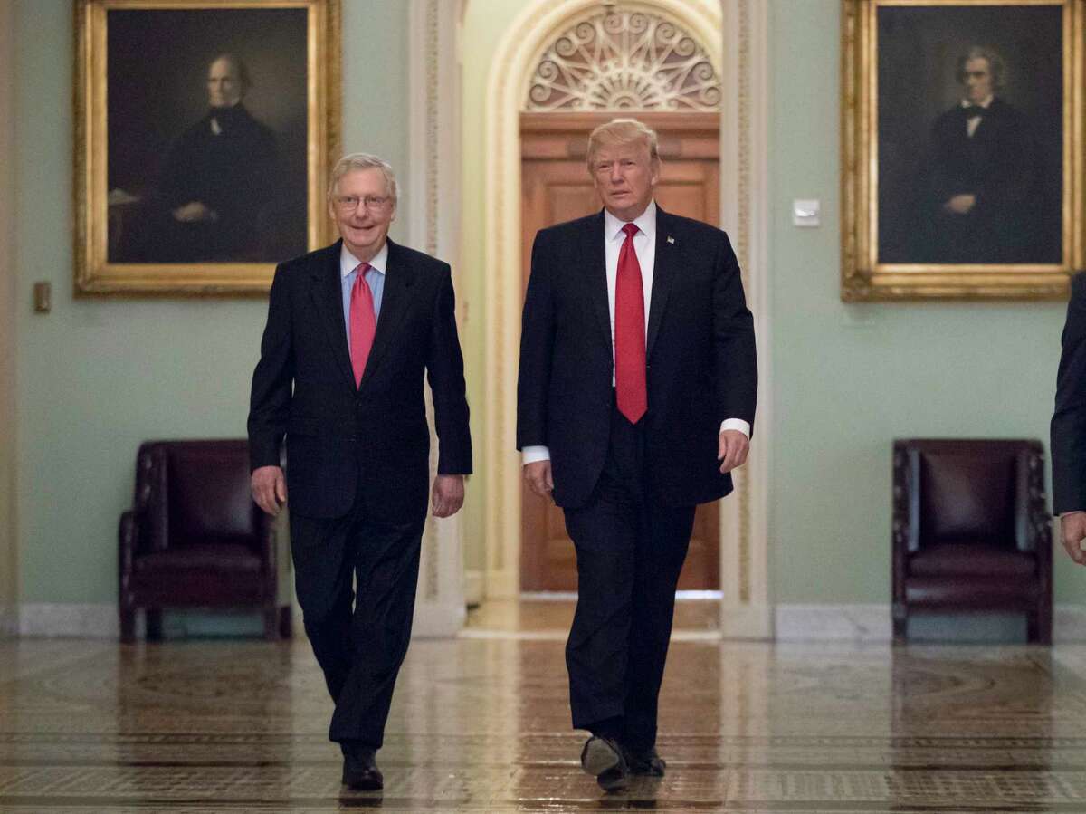 President Donald Trump, escorted by Senate Majority Leader Mitch McConnell, R-Ky., left, arrives on Capitol Hill to have lunch with Senate Republicans and push for his tax reform agenda Tuesday. (AP Photo/J. Scott Applewhite)