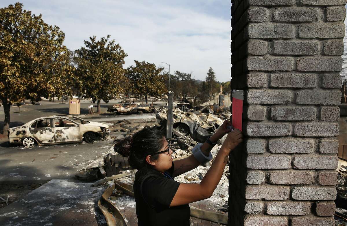 Cecilia Sevilla, Building Inspector with the Safety Assessment Program, Cal Office of Emergency Services posts signs in the wreckage of homes declaring them inhabitable in the Coffey neighborhood Oct. 17, 2017 in Santa Rosa, Calif.