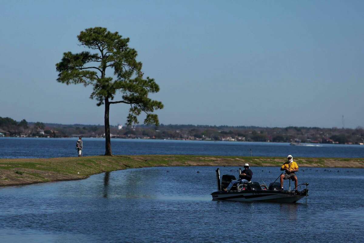 Men fish from their boat next to the Walden Yacht Club on Lake Conroe Wednesday, Feb. 22, 2017 in Montgomery. ( Michael Ciaglo / Houston Chronicle )