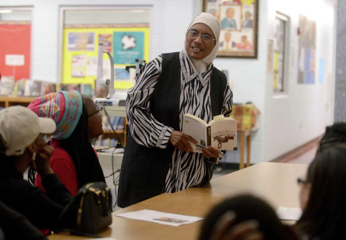 N.Y. Nathiri holds a copy of Zora Neale Hurston’s novel “Mules and Men” while speaking with children at Davis Middle School. Nathiri, like Hurston, grew up in Eatonville, Fla.