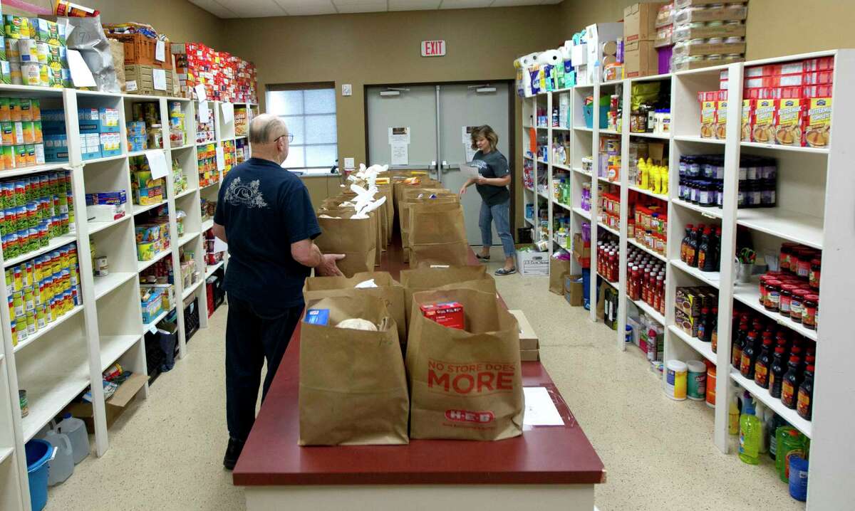 Volunteers sort bags for families at the Stonebridge Church food pantry, Thursday, in The Woodlands. The outreach program, which offers non-perishable food to families and individuals in need, was awarded $750 by the Johnson Development Corporation.