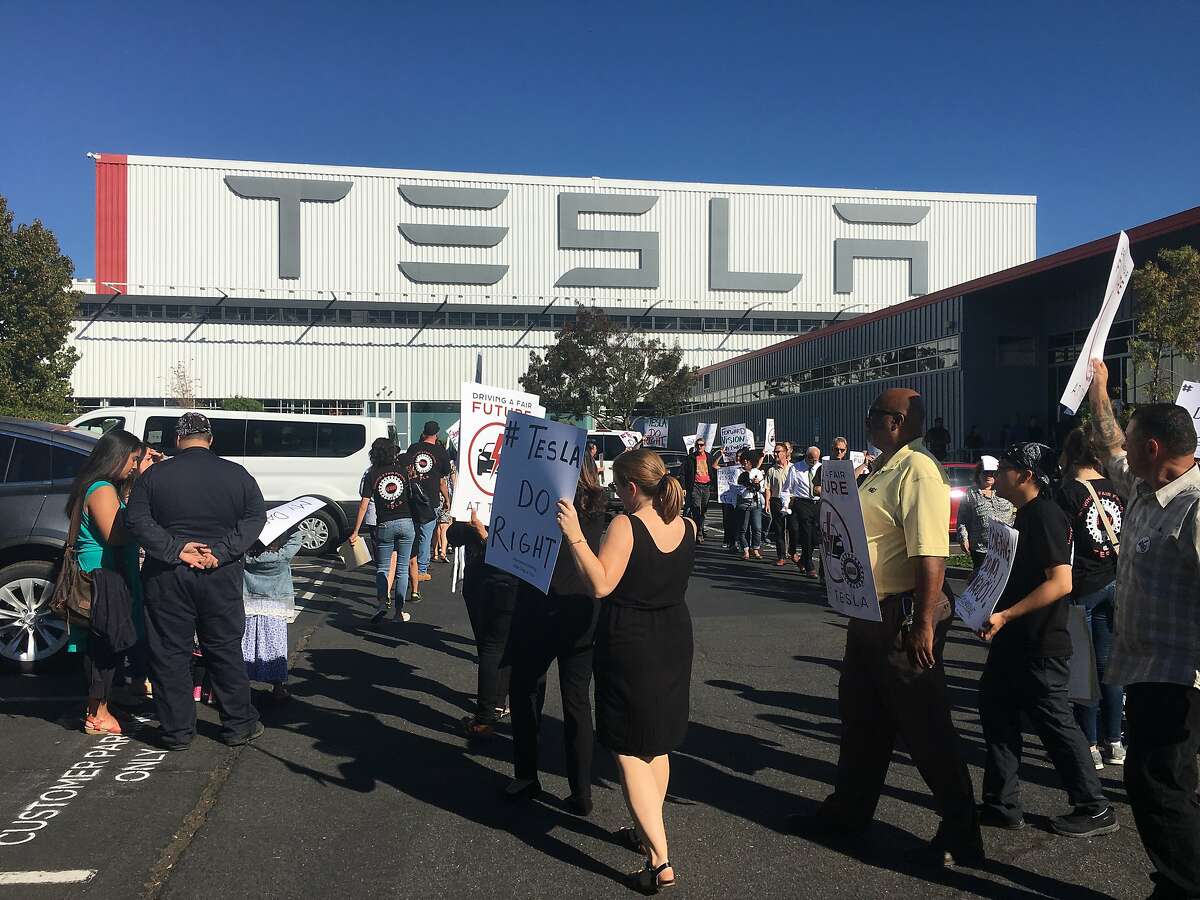 Pro-union Tesla employees rally outside the company's auto factory on Oct. 24. The United Auto Workers filed a complaint Wednesday with federal authorities accusing Tesla of firing workers for supporting the union.