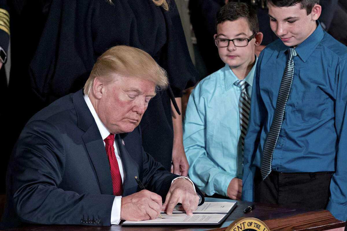 U.S. President Donald Trump signs a presidential memorandum after delivering remarks on combatting drug demand and the opioid crisis in the East Room of the White House in Washington, D.C., U.S., on Thursday, Oct. 26, 2017. Trump is instructing his administration to declare the opioid epidemic a public health emergency, a move could pave the way for a stronger federal response, allowing expanded access to telemedicine services and making grants available to those locked out of jobs because of the crisis. Photographer: Andrew Harrer/Bloomberg