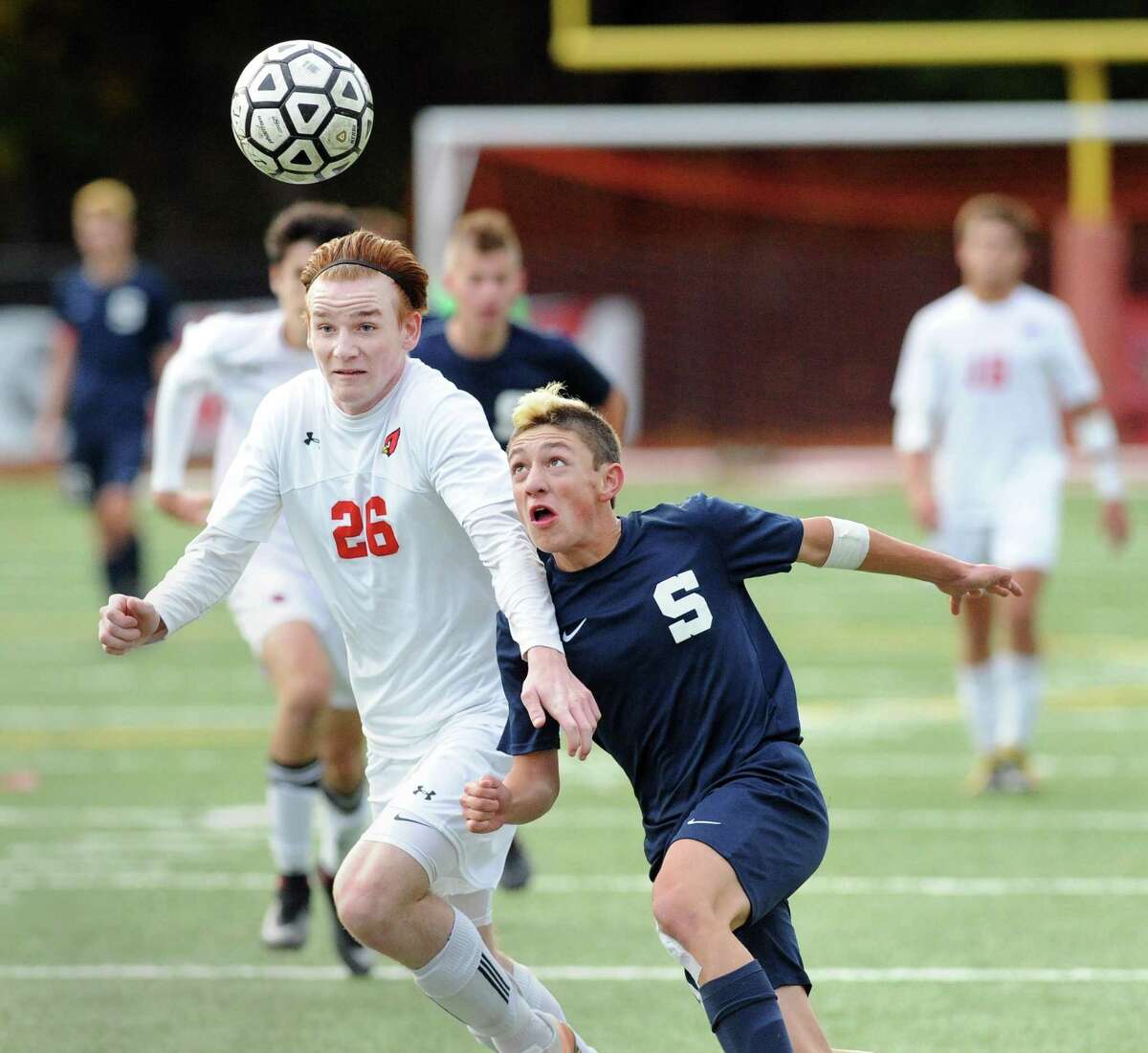 Greenwich’s Bennett Tiedy (26) goes for the ball against Staples attacker Vaughan Sealey during their FCIAC quarterfinal game on Thursday.