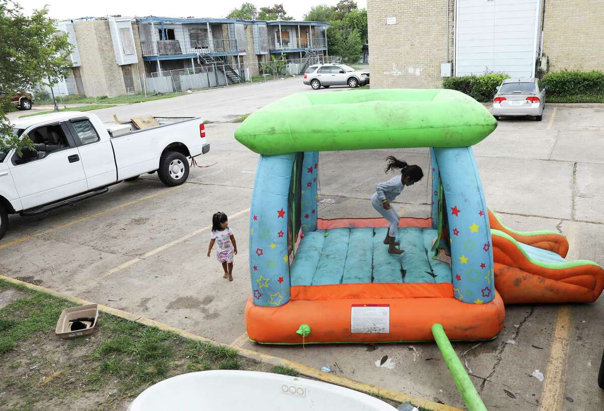 ﻿Monica Cruz﻿ jumps in an inflatable bouncy house ﻿in the parking lot ﻿at Rockport Apartments. Some tenants are making their own repairs to their apartments flooded by Hurricane Harvey. ﻿