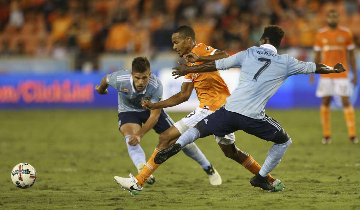 Houston Dynamo midfielder Ricardo Clark (13) battles with Sporting Kansas City players Diego Rubio (11) and Gerso Fermandes (7) for control of the ball during the first half of the first-round playoff MLS match at BBVA Compass Stadium Thursday, Oct. 26, 2017, in Houston. ( Yi-Chin Lee / Houston Chronicle )
