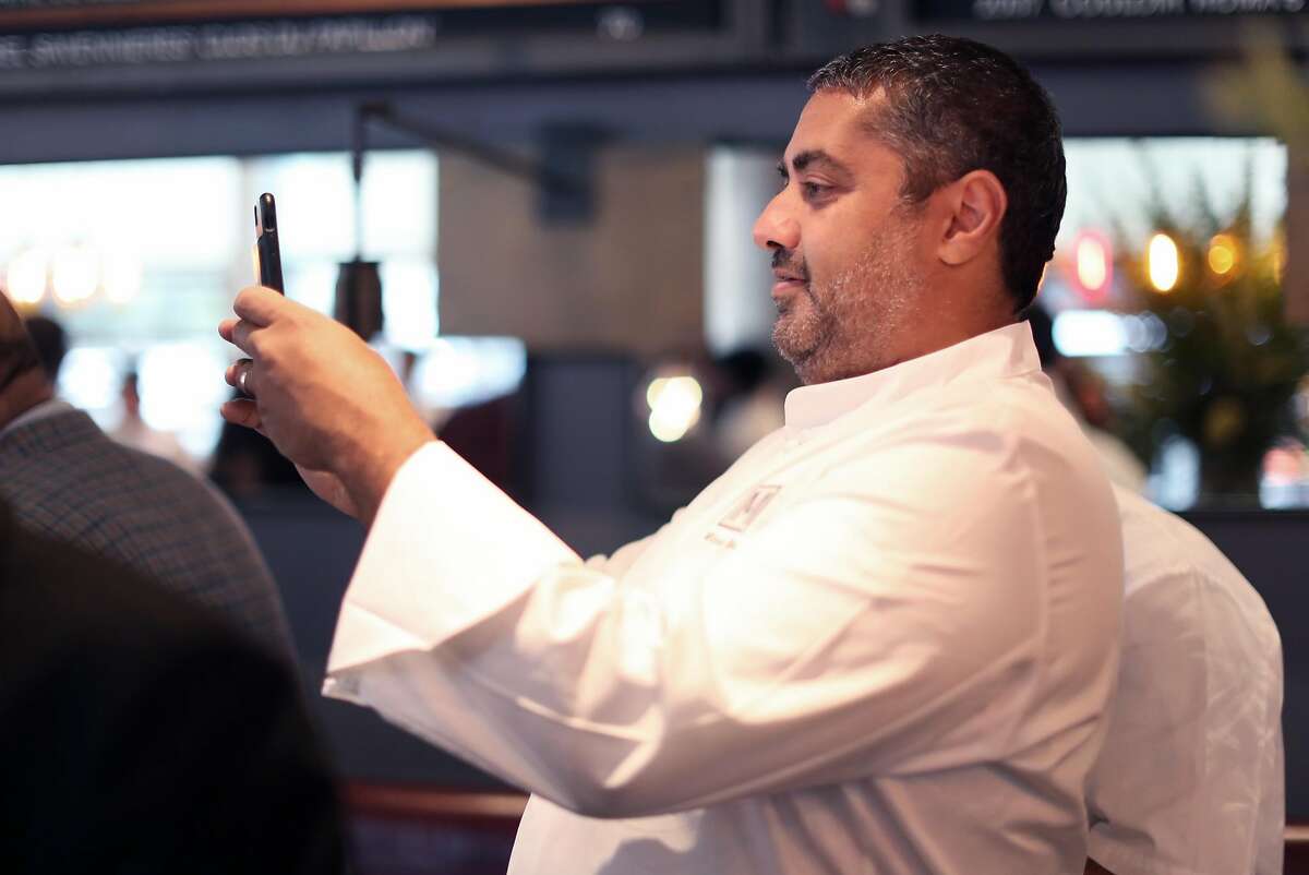 RN74 founder, Michael Mina, photographs original chef Jason Berthold as he leads the preshift meeting at RN74 in San Francisco, Calif., on Monday, September 18, 2017. The famed restaurant will serve its final meal on October 7th to make way for Ayesha Curry's new restaurant, International Smoke.