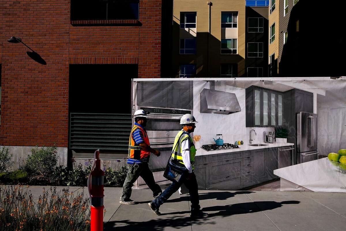 People walk past the Avalon apartments in the Dogpatch neighborhood of San Francisco, Calif., on Thursday, Oct. 26, 2017.