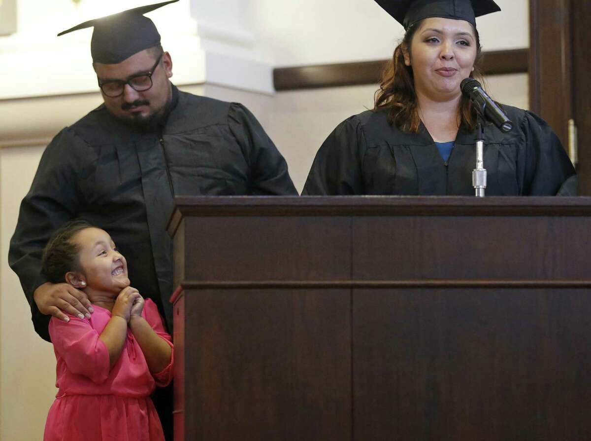 Ethan Ybarra looks down at his beaming 5-year-old daughter, Jewel Ybarra, as she listens to her mother, Danielle Ramirez, talk about her experience with and graduation from Bexar County’s family drug court in the Bexar County Courthouse.