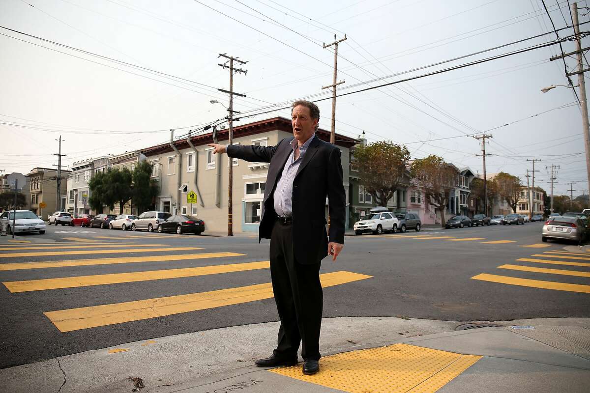 Larry Baer demonstrates his crossing-guard duty on the streets of the Outer Richmond District, his childhood neighborhood.