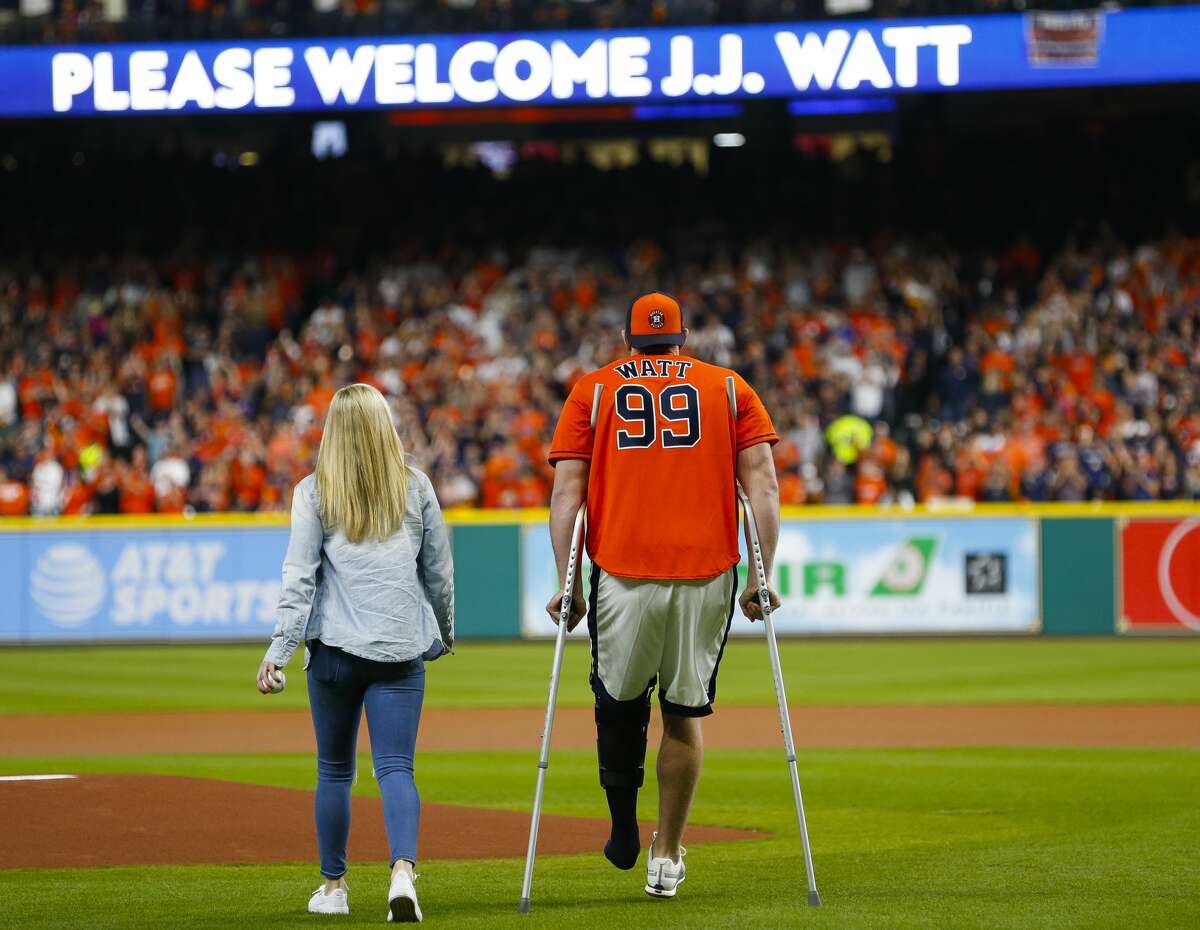 J.J. Watt walks onto the field with Kealia Ohai before throwing out the ceremonial first pitch before Game 3 of the World Series at Minute Maid Park on Friday, Oct. 27, 2017, in Houston.