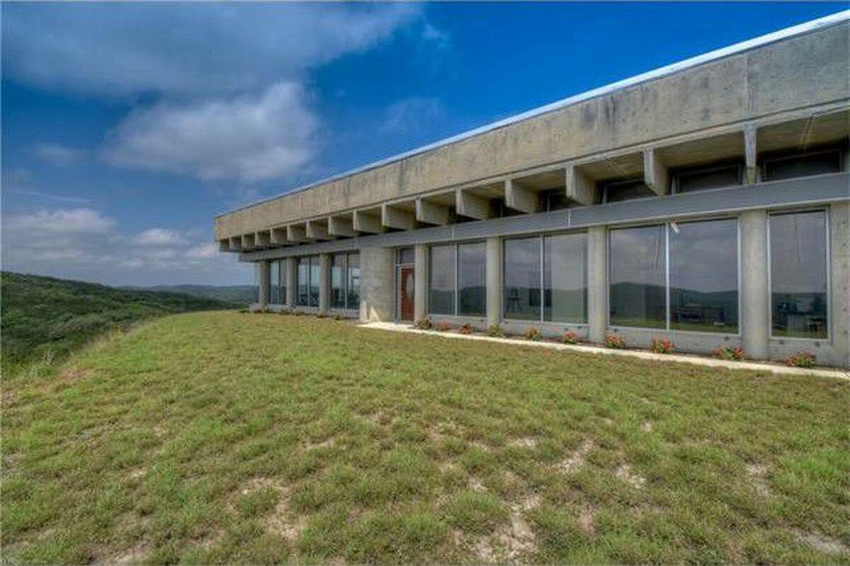 A little more than an hour's drive from San Antonio, near Leakey, sits this concrete and glass Brutalist style home built into a hillside. Asking price is $949,00.