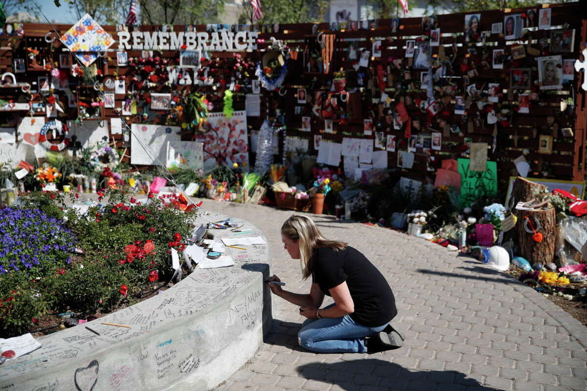 Jenni Tillett writes a message at a Las Vegas memorial for the victims of the recent mass shooting.