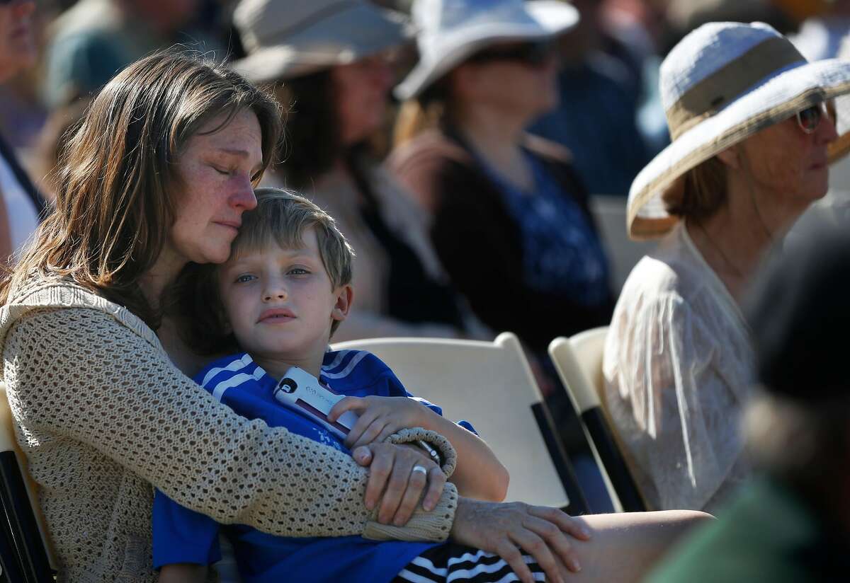 Laura Schulze holds her son Zachary, 8, during the Sonoma County Day of Remembrance at Santa Rosa Junior College Oct. 28, 2017 in Santa Rosa, Calif. The day memorialized those lives and homes lost in the devastating fires that ripped through the community mere weeks before, killing dozens and destroying thousands of structures, displacing hundreds of people.