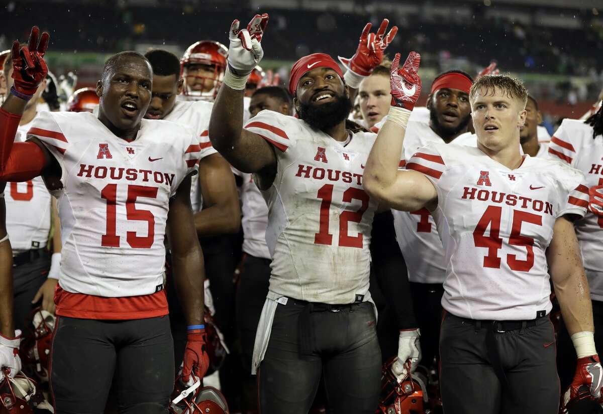 Houston players, from left, wide receiver Linell Bonner (15), linebacker D'Juan Hines (12) and linebacker Cameron Doubenmier (45) celebrate after the team defeated South Florida 28-24 during an NCAA college football game, Saturday, Oct. 28, 2017, in Tampa, Fla. (AP Photo/Chris O'Meara)