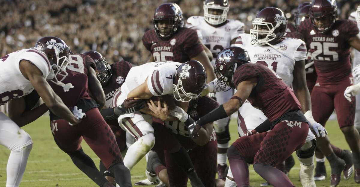 Mississippi State quarterback Nick Fitzgerald (7) cross the goal line for a touchdown as Texas A&M defensive lineman Landis Durham (46) and Kingsley Keke (88) defend during the first quarter of an NCAA college football game on Saturday, Oct. 28, 2017, in College Station, Texas. (AP Photo/Sam Craft)