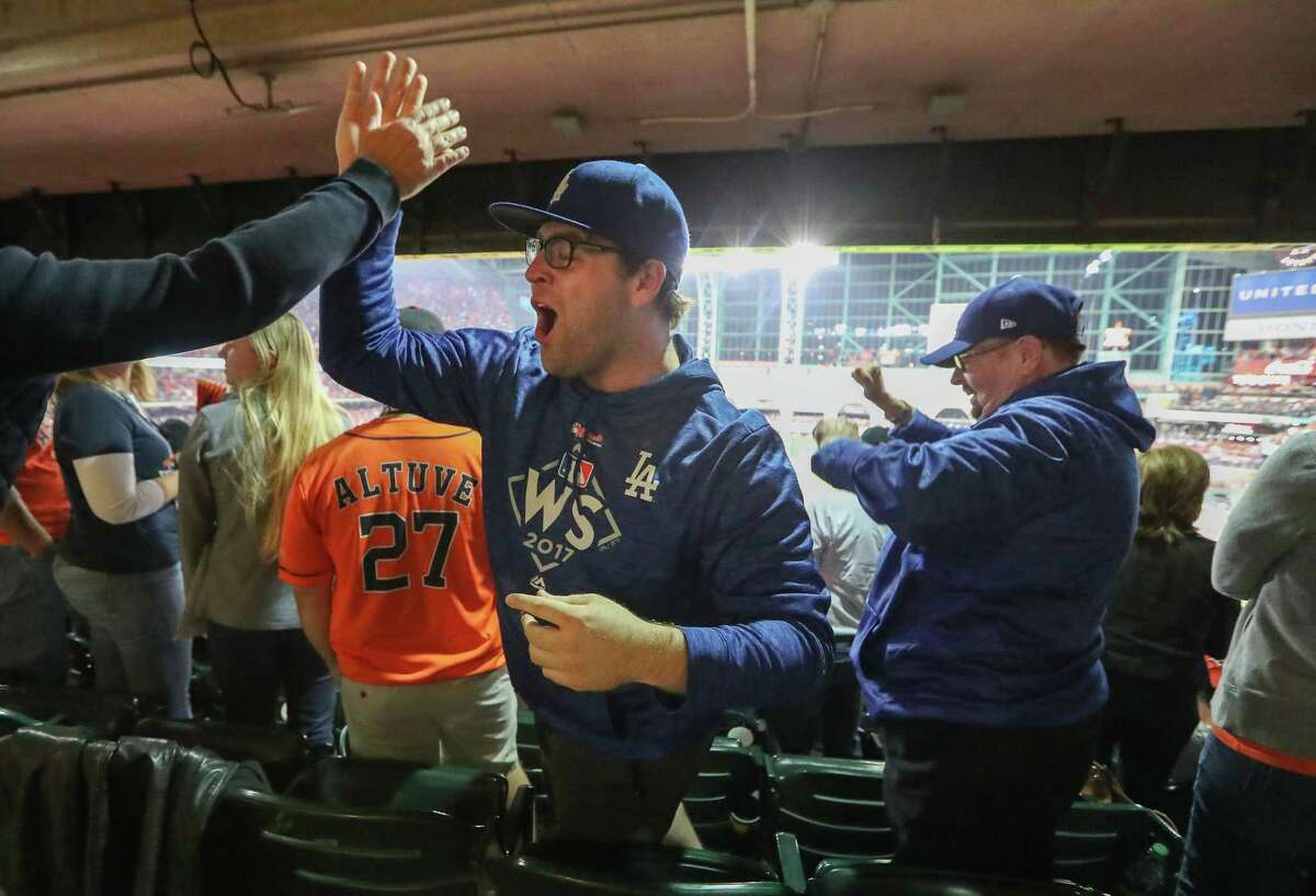 Dodgers fans Ryan Daly and his father, John (right), celebrate after LA's Joc Pederson hit a homer in the 9th inning of World Series Game 4 Saturday, Oct. 28, 2017, in Houston.