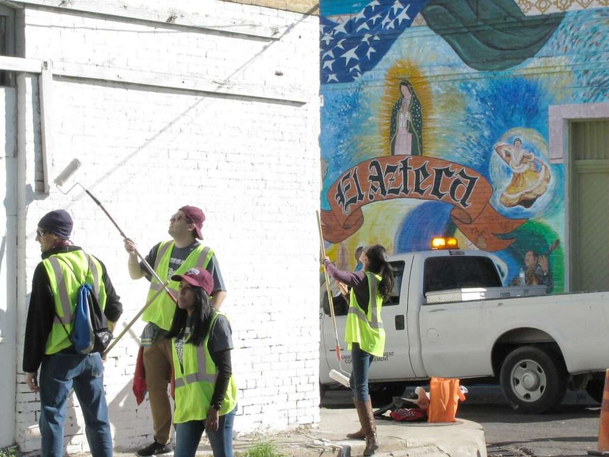 Estudiantes de la universidad Texas A&M International University pintan un edificio en el Barrio Azteca el sábado, durante el evento Make a Difference Day. Estudiantes, profesorado y personal de TAMIU participaron en el proyecto de servicio a la comunidad en este barrio histórico.