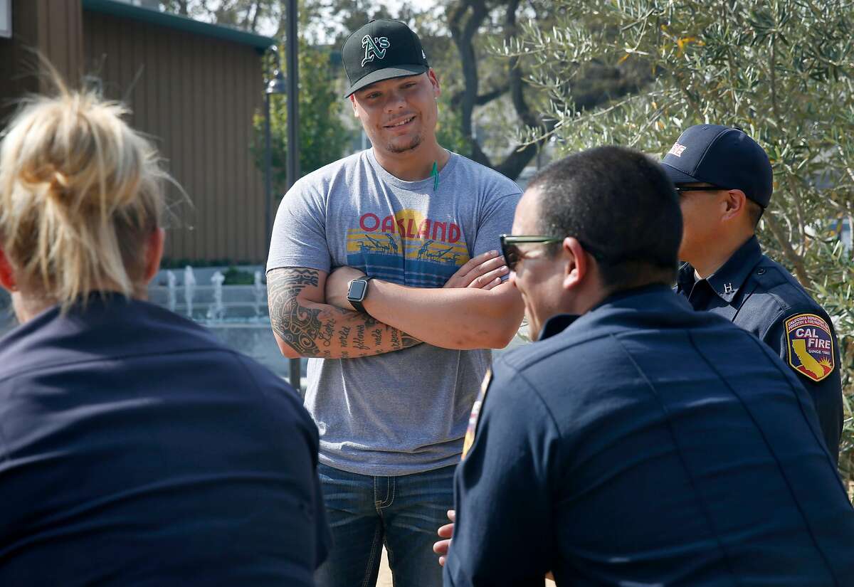 Oakland A's catcher Bruce Maxwell visits with firefighters in the Cal Fire base camp at the Sonoma County Fairgrounds in Santa Rosa, Calif. on Tuesday Oct. 17, 2017.