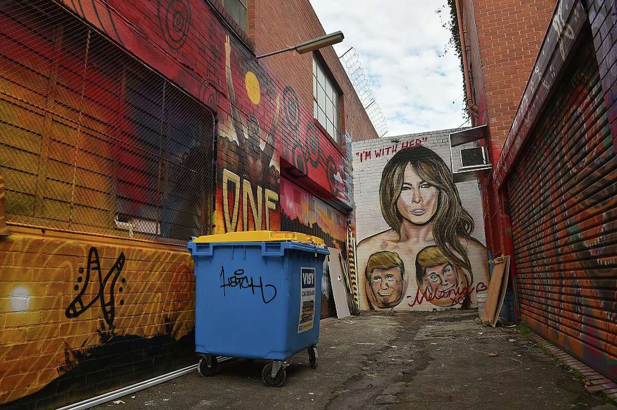 A mural depicting Republican US presidential nominee Donald Trump over the breasts of his wife Melania, created by street artist Lushsux, is seen on a wall in West Footscray in Melbourne on July 30, 2016. An Australian mural of US presidential nominee Hillary Clinton in a revealing, stars and stripes swimsuit may be taken down, after it has reportedly been deemed offensive. The creator of the painting, the street artist who goes by the name Lushsux and who has also painted murals of the likes of Donald Trump and Kim Kardashian, branded calls to remove it "pathetic". / AFP / Paul Crock / RESTRICTED TO EDITORIAL USE - MANDATORY MENTION OF THE ARTIST UPON PUBLICATION - TO ILLUSTRATE THE EVENT AS SPECIFIED IN THE CAPTION (Photo credit should read PAUL CROCK/AFP/Getty Images)